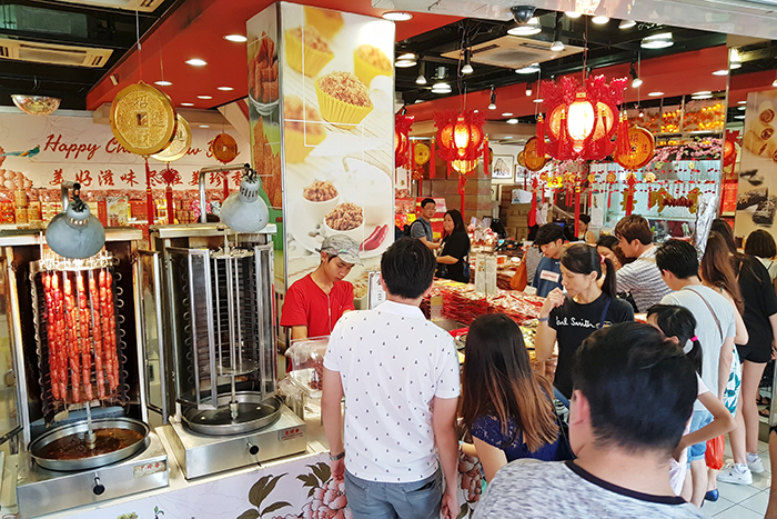  
People line up for deep red slices of <i>bakkwa</i> (Chinese pork jerky). Eating this is believed to attract good luck in the new year. 
